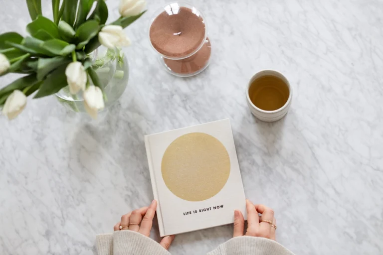 Aesthetic stock image of the five minute journal on a white shelving unit. The image is for decorative use only to support the blog post on the best gratitude journals.