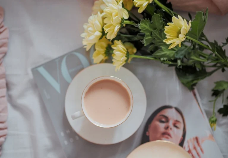 Aesthetic stock image showing a cup of tea on a Vogue magazine next to a bunch of yellow flowers. The image is purely for decorative us only to support the blog post on the hobbies I’m building in my 30s to heal from burnout.