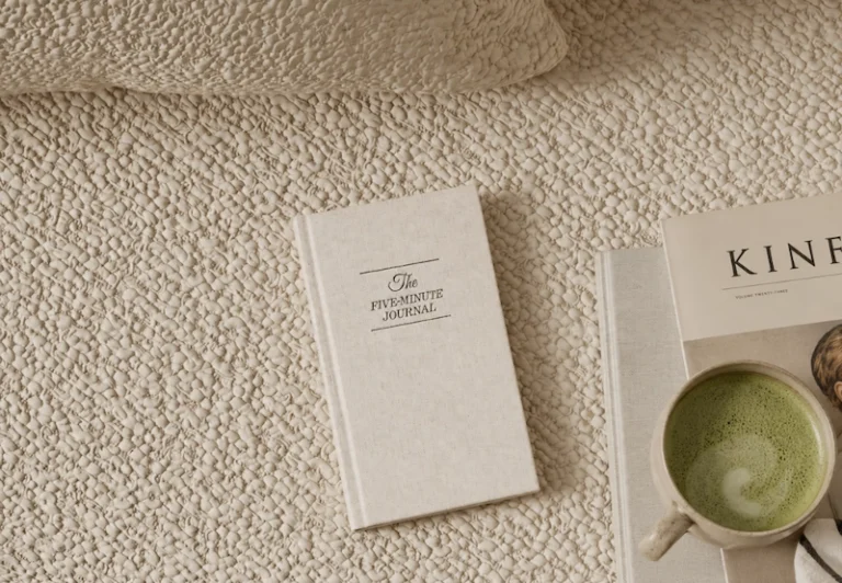 Aesthetic stock image showing The Five Minute Journal on a beige boucle carpet next to a mug of matcha latte. The image is purely for decorative us only to support the blog post on Things I’m actually spending money on to recover from burnout.