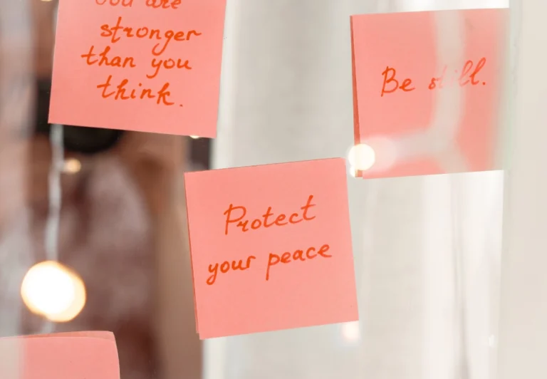 Aesthetic stock image showing a collection of post it notes on the mirror. The one in the centre says “protect your peace.” The image is purely for decorative use only to support the blog post on how to stop people pleasing.