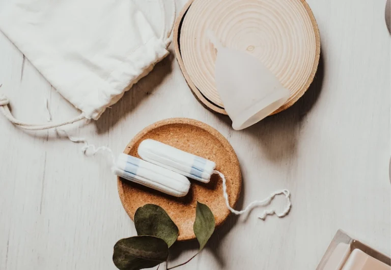 A stylised picture of tampons, a sanitary pad and moon cup which are things someone would use during their period