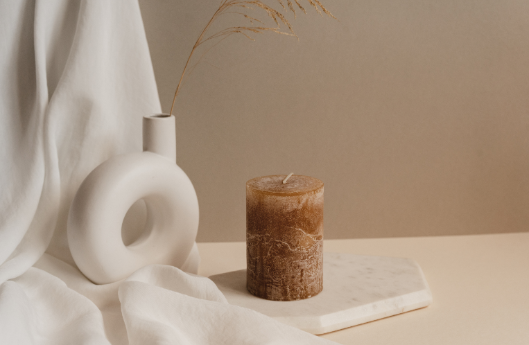 Aesthetic stock image showing a white circle vase on top of a white chiffon scarf and next to a brown candle. The image is purely for decorative use only to support the blog post on positive affirmations for women