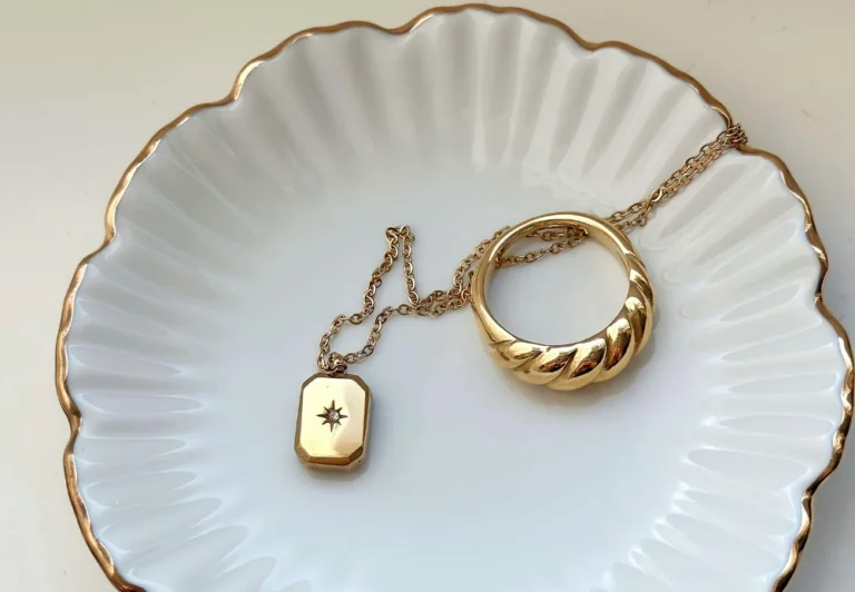 Aesthetic stock image showing necklace with a small compass pendant and gold ring on a white jewellery plate. The image is purely for decorative us only to support the blog post on the reasons why women in their mid-twenties and thirties are feeling lost in life.