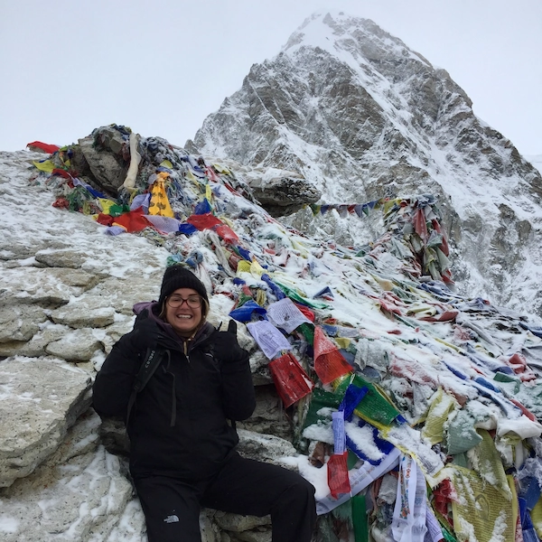 Lifestyle photo showing author of Notes by Thalia, Thalia posing on the peak of a mountain in the Himalayas