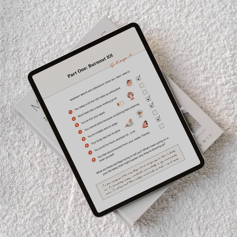 iPad device showing a page from the Stay & Slay Workbook. The iPad is lying on a white boucle sofa